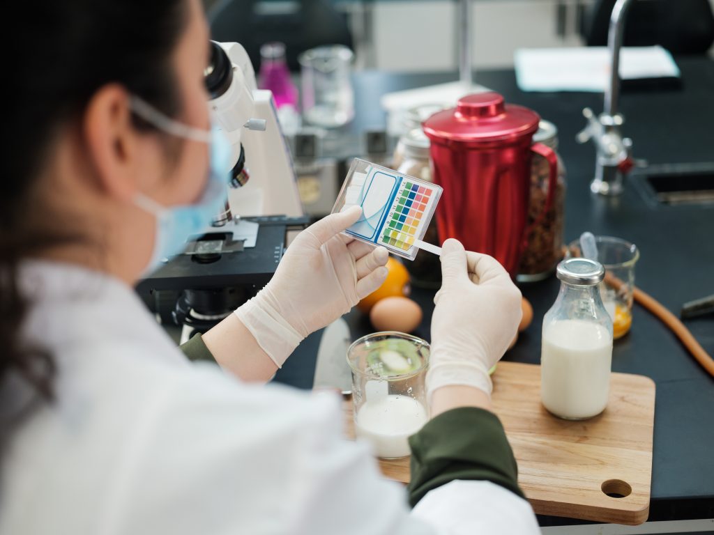 A woman in a lab testing milk with color strips